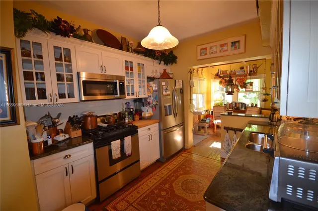 a kitchen with stainless steel appliances granite countertop a stove refrigerator and cabinets