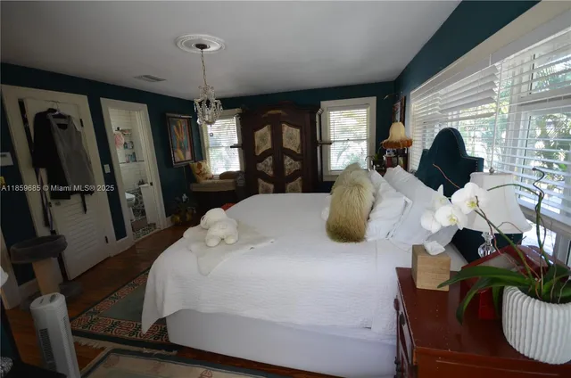 a large bed sitting in a bedroom next to a window