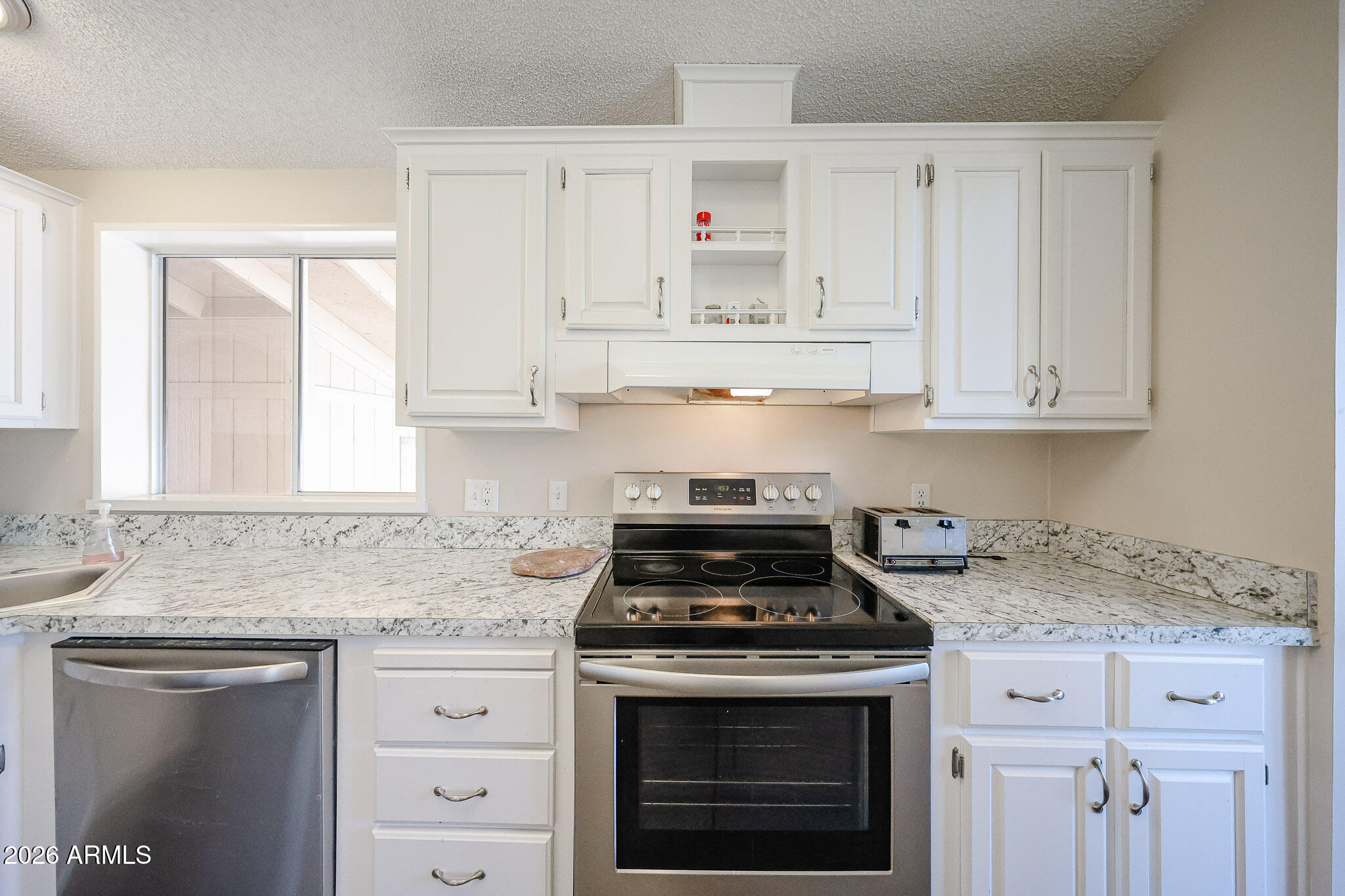 3901 East Pinnacle Peak Road, Unit 355 Phoenix, AZ 85050 - Photo 11 of 29 a kitchen with granite countertop white cabinets and white appliances