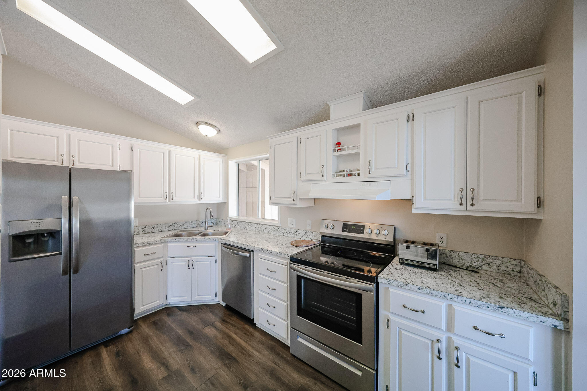 3901 East Pinnacle Peak Road, Unit 355 Phoenix, AZ 85050 - Photo 8 of 29 a kitchen with stainless steel appliances granite countertop a sink stove and refrigerator
