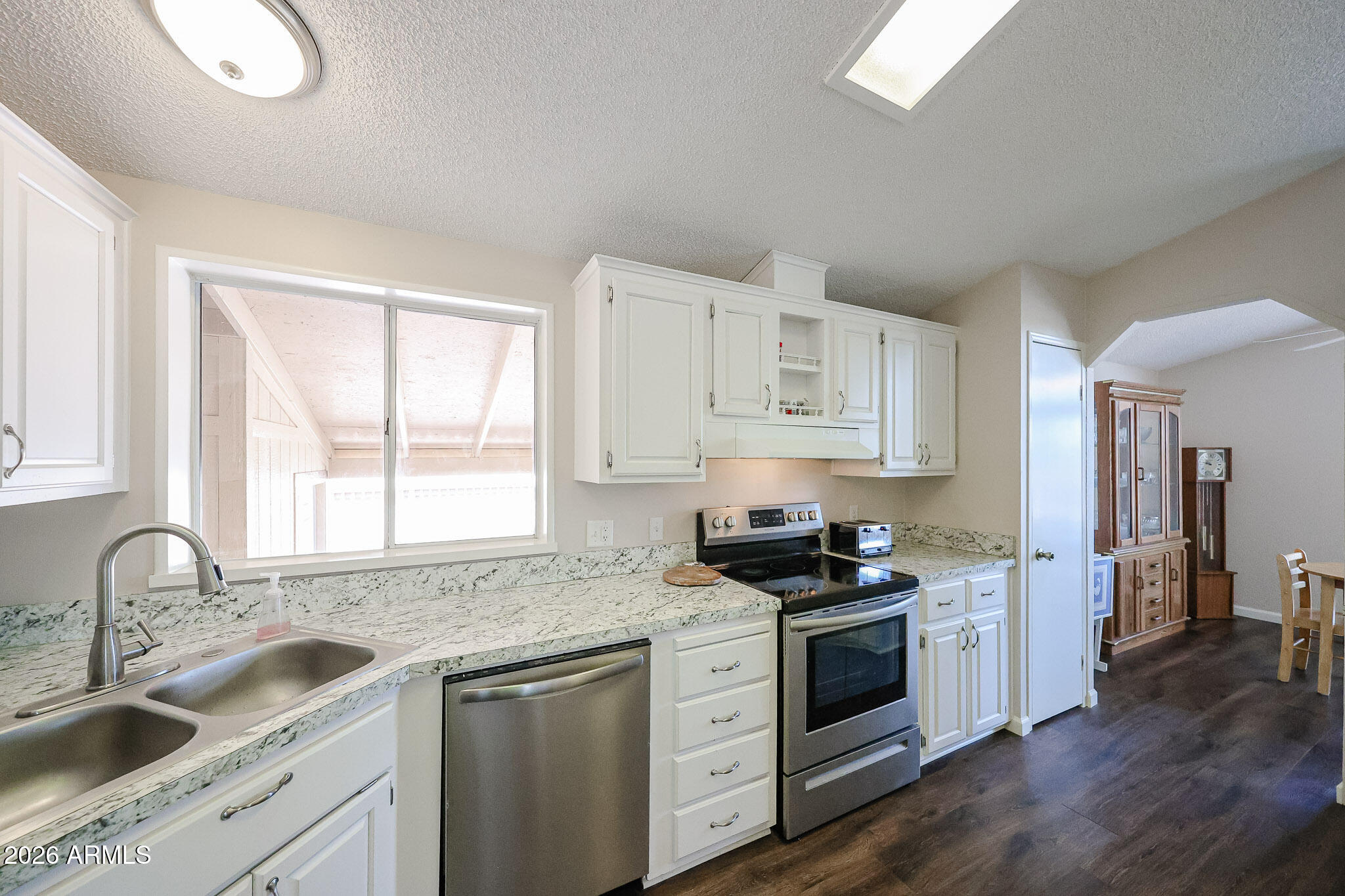 3901 East Pinnacle Peak Road, Unit 355 Phoenix, AZ 85050 - Photo 9 of 29 a kitchen with granite countertop white cabinets and white appliances