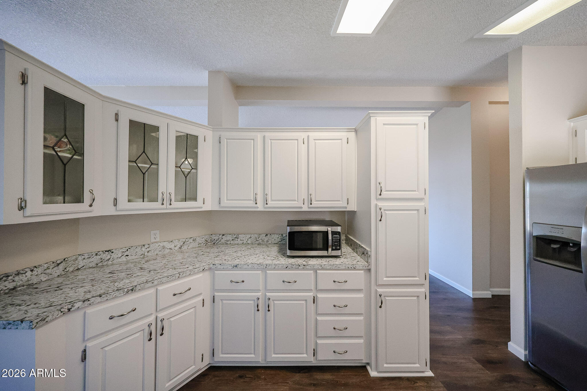 3901 East Pinnacle Peak Road, Unit 355 Phoenix, AZ 85050 - Photo 10 of 29 a kitchen with granite countertop white cabinets and stainless steel appliances