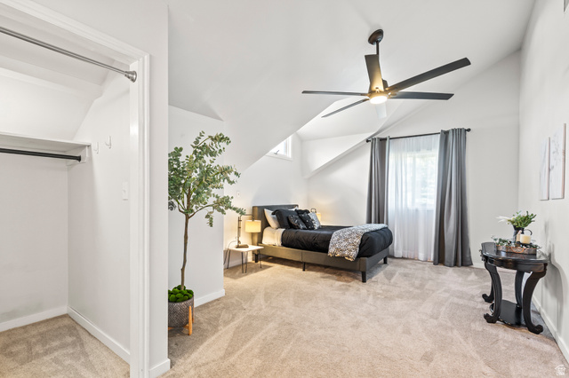 460 Omni Point Road Central Valley, UT 84754 - Photo 57 of 101 Carpeted bedroom featuring a vaulted ceiling with a ceiling fan, a window with curtains, and a built-in closet with shelving and hanging rod