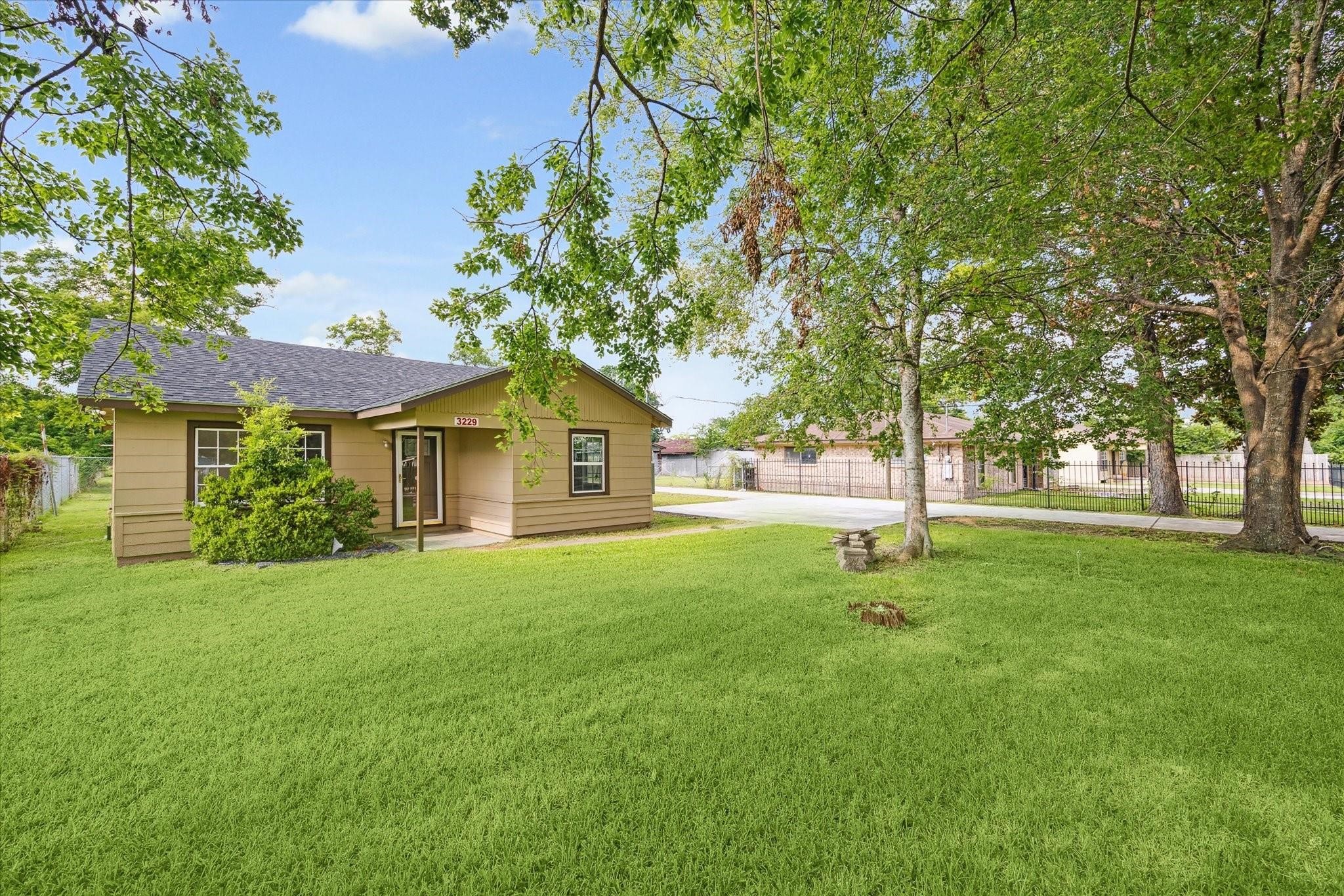 3229 Persimmon Street Houston, TX 77093 - Photo 3 of 8 a front view of a house with a yard and trees