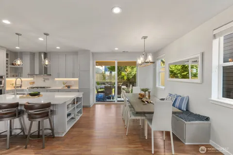 a living room with stainless steel appliances kitchen island granite countertop furniture and a wooden floor