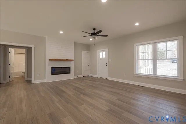 an empty room with windows and a fireplace