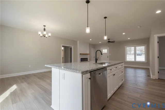 a kitchen with granite countertop a sink cabinets and wooden floor
