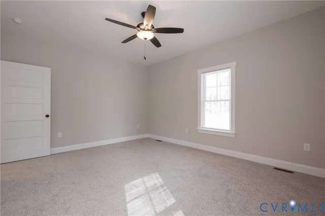 an empty room with a window and a fan