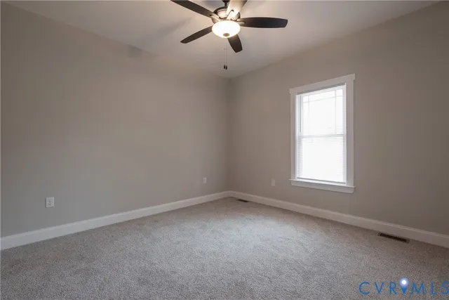 an empty room with a window and a fan