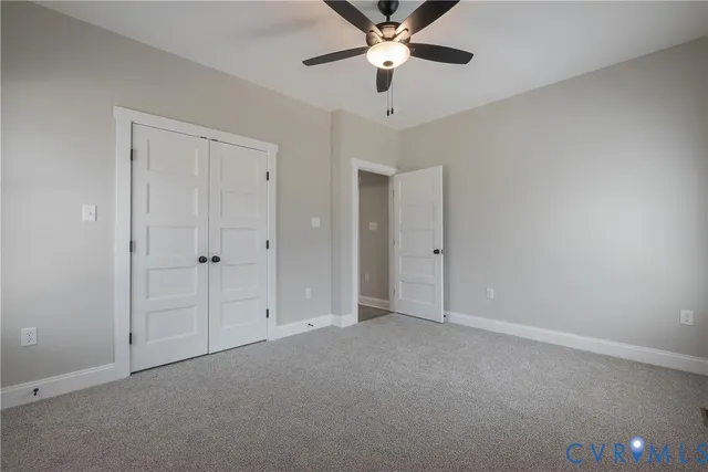 an empty room with chandelier fan