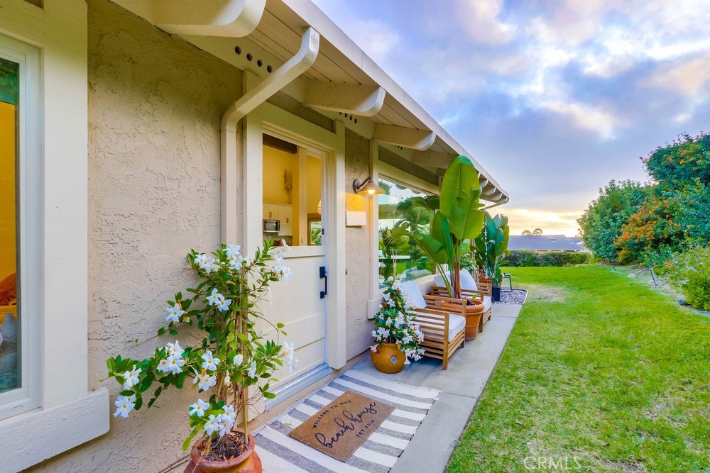 a view of a chair and table in backyard of the house