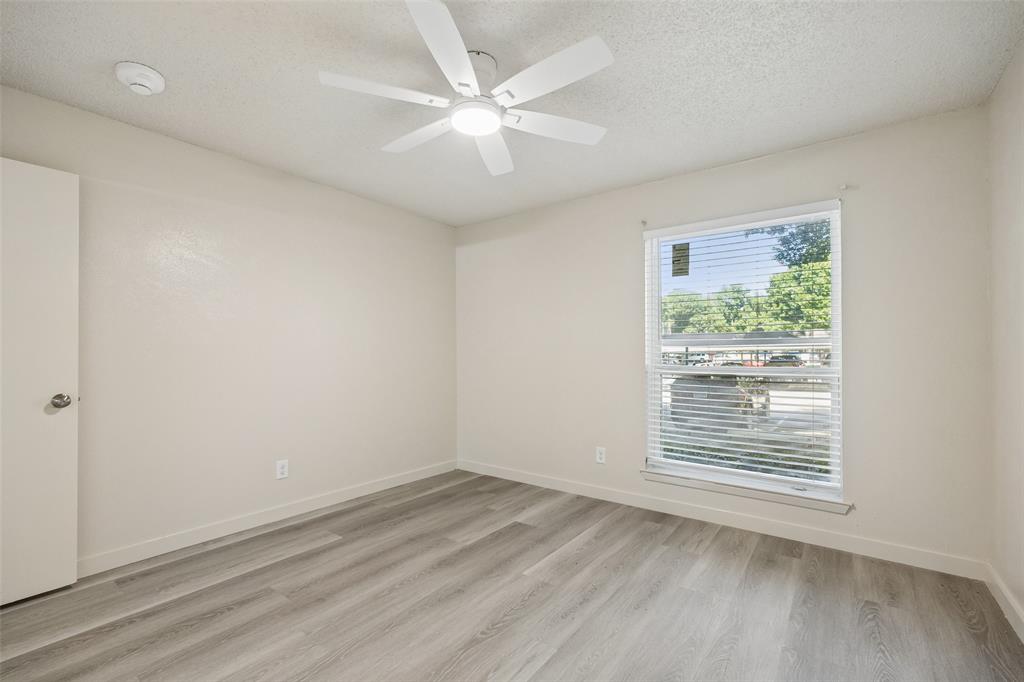 11480 Audelia Road, Unit 136 Dallas, TX 75243 - Photo 27 of 29 Spacious room featuring light-toned walls, wood-finish flooring, a ceiling fan with integrated lighting, and a window with horizontal blinds