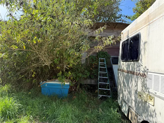 a backyard of a house with lots of plants and wooden fence