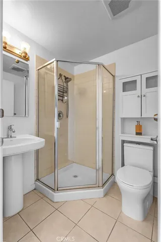 a bathroom with a shower a toilet and a sink