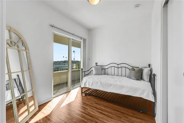 a large bedroom with a bed and wooden floor