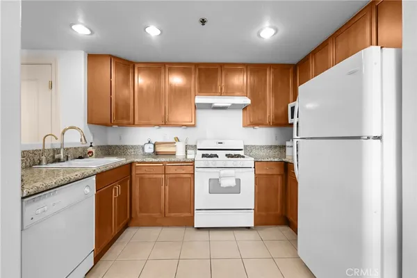 a kitchen with a refrigerator sink and cabinets