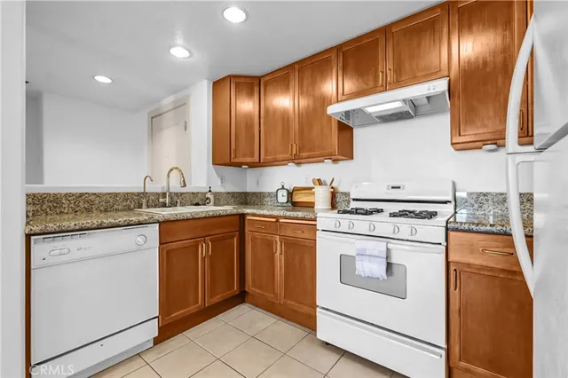 a kitchen with granite countertop stainless steel appliances and wooden cabinets