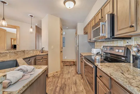 a kitchen with stainless steel appliances granite countertop a sink stove and refrigerator