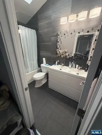 a bathroom with a double vanity sink toilet and mirror