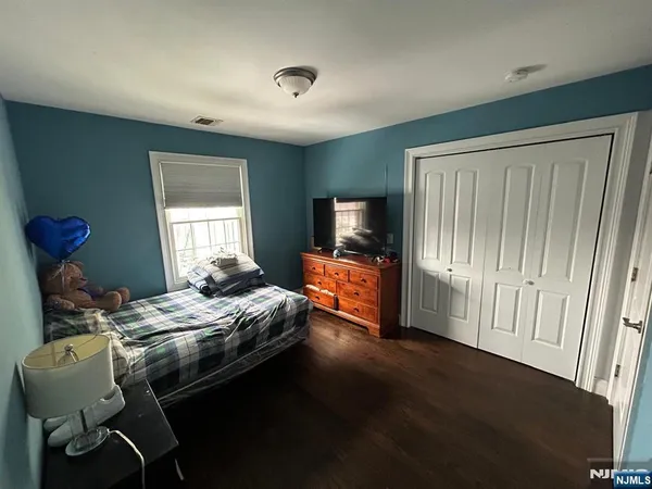 a bedroom with bed tv and window