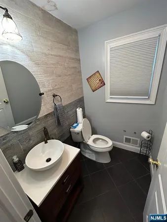 a bathroom with a sink a toilet and a mirror