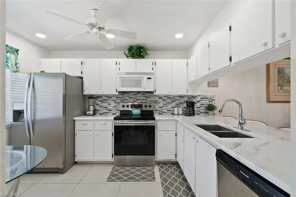 a kitchen with stainless steel appliances granite countertop a refrigerator and a stove top oven