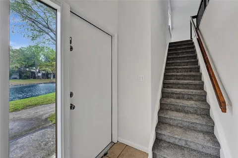 a view of a hallway with wooden floor and entryway
