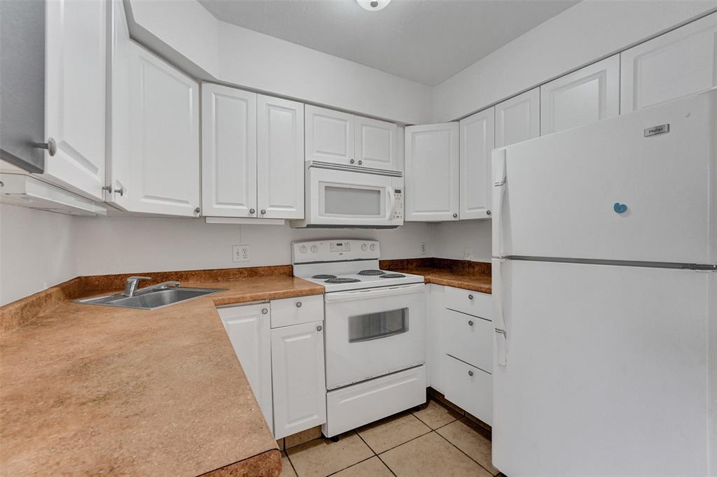 26 Wimbledon Lakes Drive, Unit 248 Plantation, FL 33324 - Photo 9 of 26 a kitchen with white cabinets and white appliances