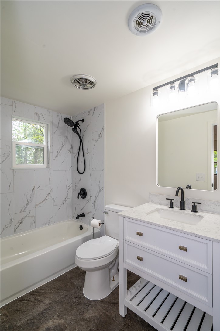 11296 Pansing Road Brookville, OH 45309 - Photo 22 of 53 This bathroom features a contemporary vanity and elegant tile work, creating a sleek and inviting atmosphere.