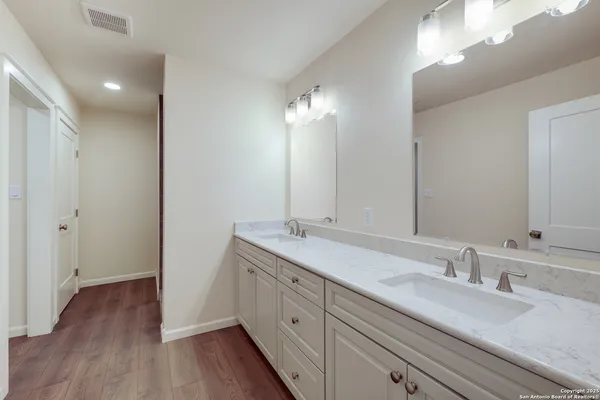 a bathroom with a double vanity sink and a mirror