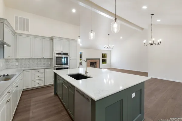 a kitchen with a stove sink and cabinets
