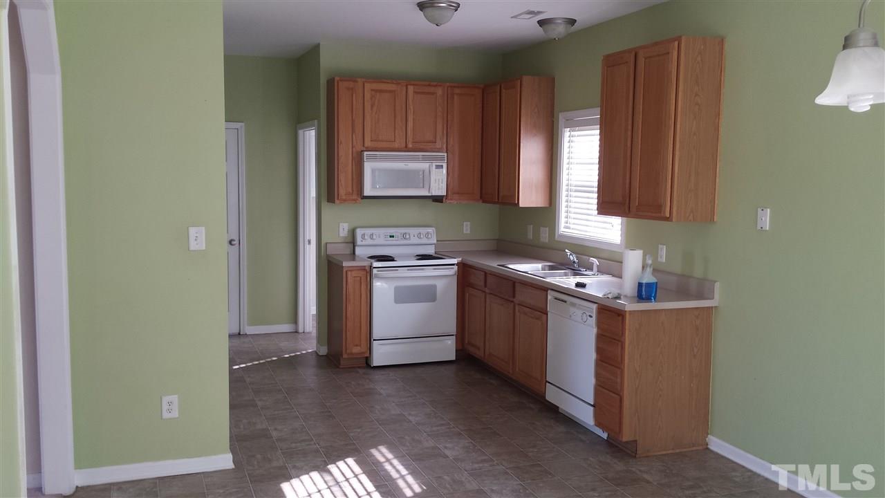 6912 Missionary Ridge Drive Raleigh, NC 27610 - Photo 11 of 16 a kitchen with a stove top oven cabinets and a window