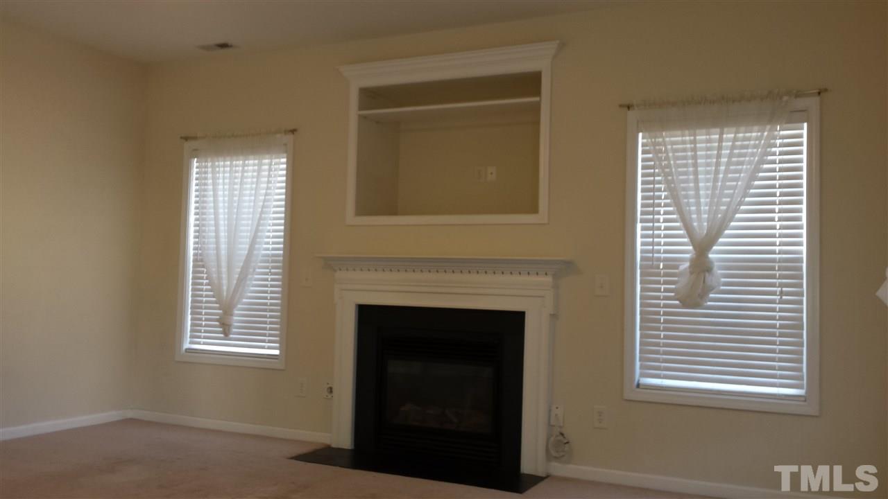 6912 Missionary Ridge Drive Raleigh, NC 27610 - Photo 7 of 16 a living room with a fireplace and windows