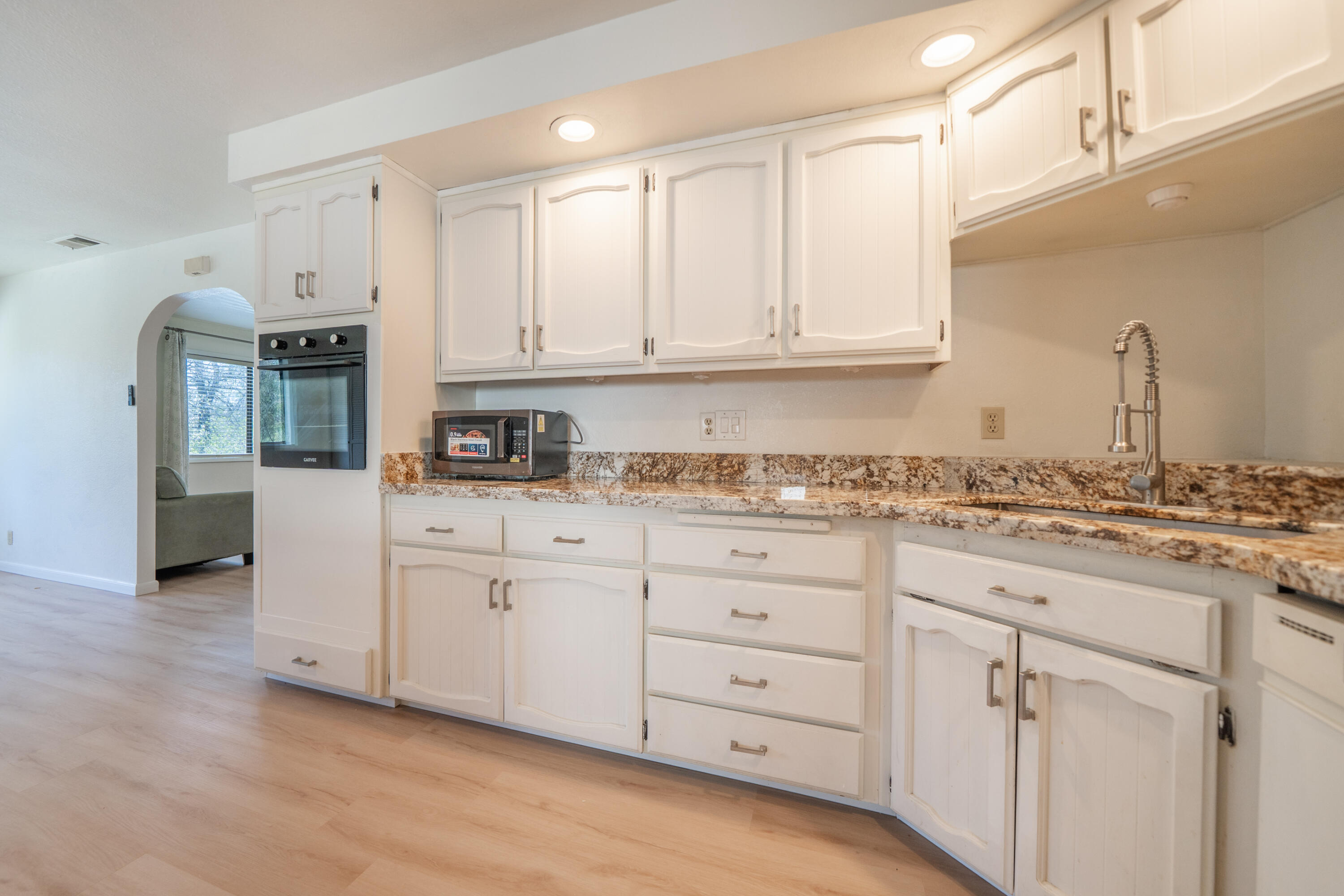 2580 Keswick Dam Road Redding, CA 96003 - Photo 17 of 60 a kitchen with granite countertop white cabinets and white appliances