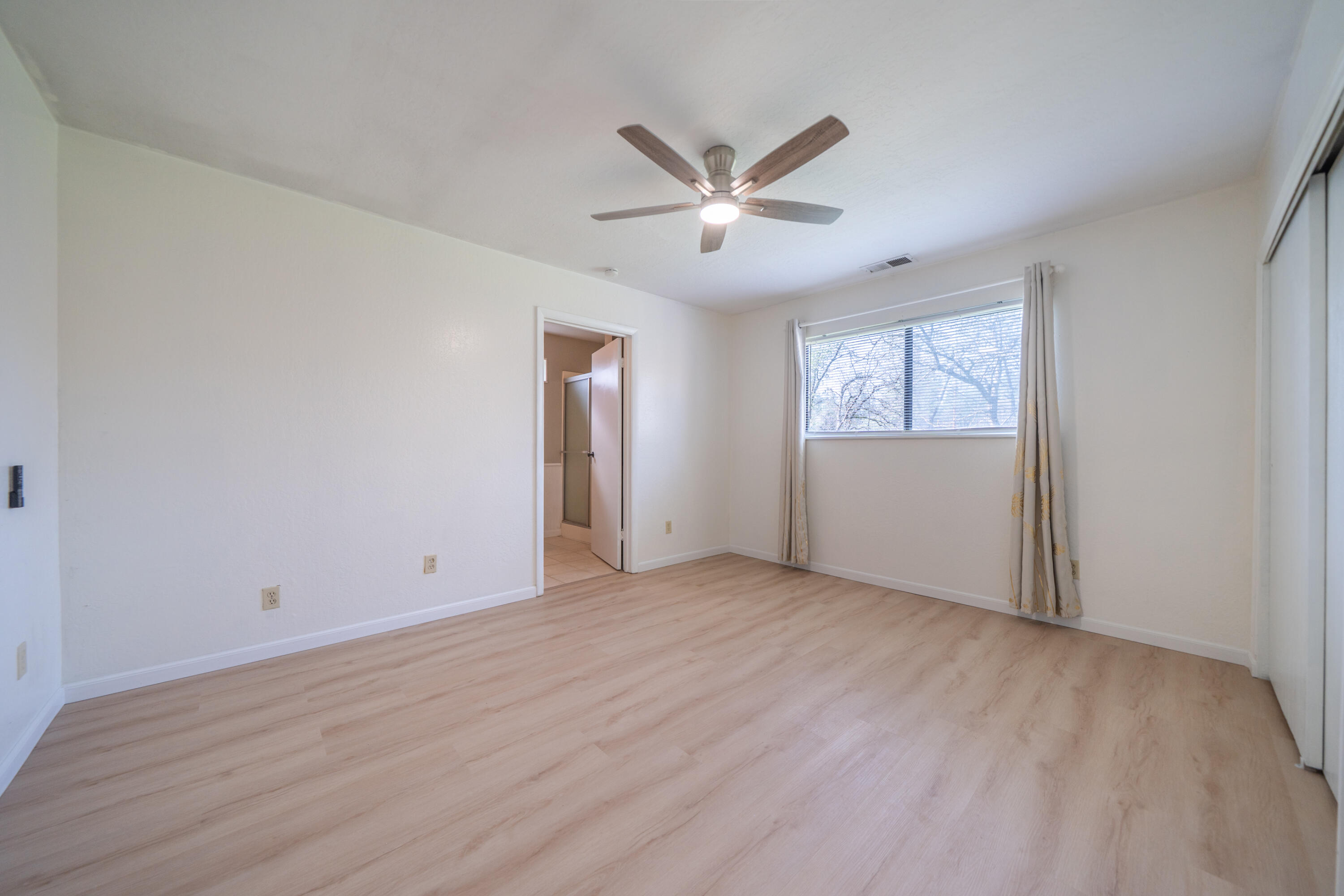 2580 Keswick Dam Road Redding, CA 96003 - Photo 25 of 60 a view of an empty room with wooden floor and a window
