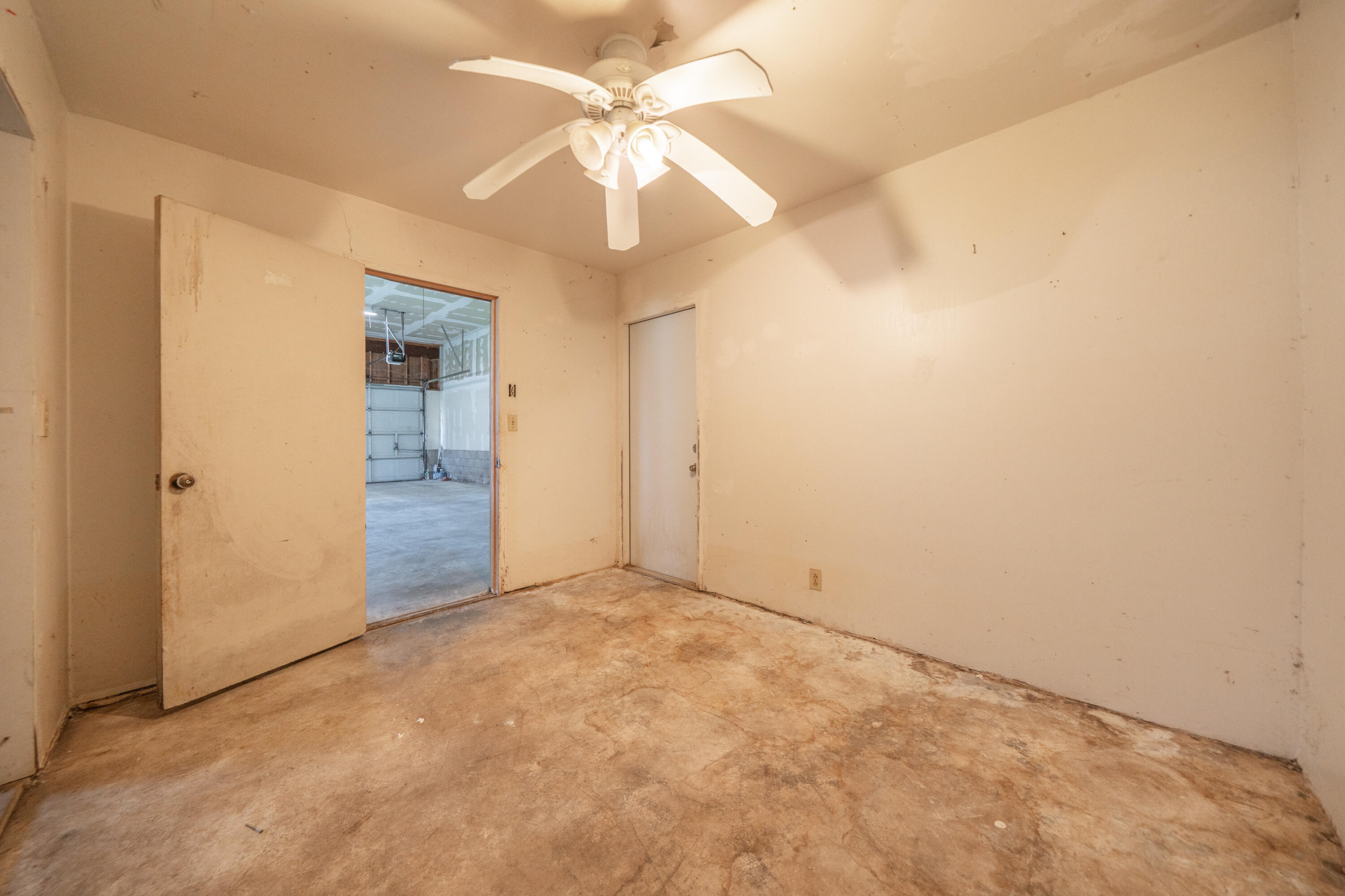 2580 Keswick Dam Road Redding, CA 96003 - Photo 36 of 60 an empty room with a chandelier fan and windows