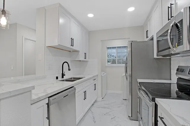 a kitchen with stainless steel appliances granite countertop a sink stove and refrigerator