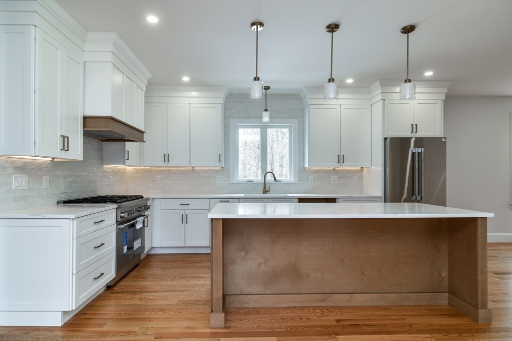 75 Cottage Street Natick, MA 01760 - Photo 7 of 37 a large kitchen with granite countertop a stove a sink a refrigerator and a wooden floor