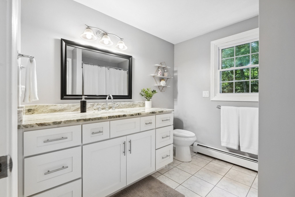 66 Dodge Road Sutton, MA 01590 - Photo 26 of 38 a bathroom with a granite countertop toilet sink and mirror