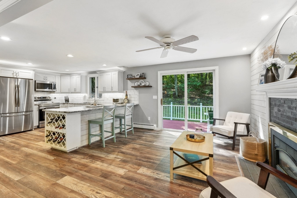 66 Dodge Road Sutton, MA 01590 - Photo 9 of 38 a living room with stainless steel appliances kitchen island granite countertop furniture and a fireplace