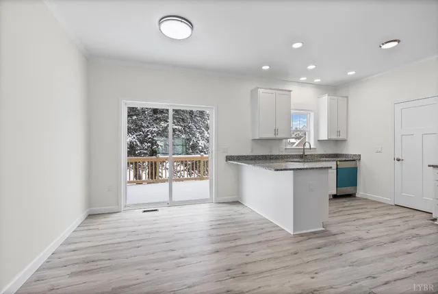 a large white kitchen with kitchen island white cabinets and wooden floor