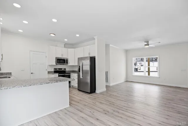 a kitchen with stainless steel appliances granite countertop a refrigerator sink and stove