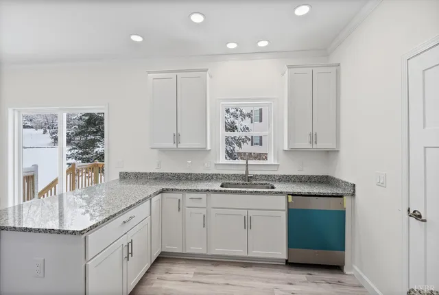 a kitchen with granite countertop a sink stainless steel appliances and cabinets