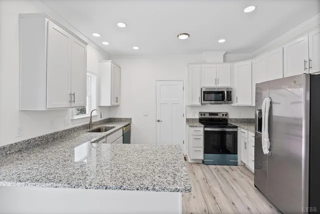 a kitchen with stainless steel appliances granite countertop a refrigerator sink and stove