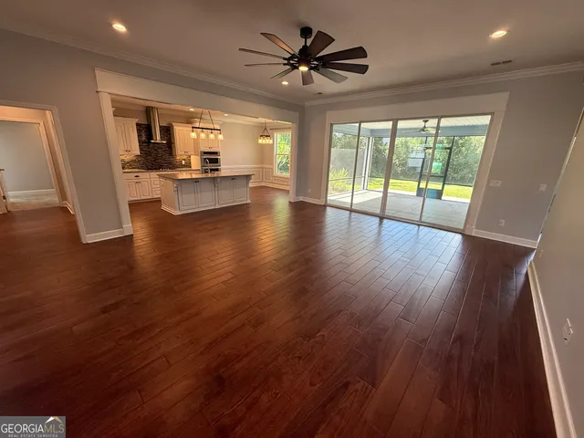 an empty room with a window and a chandelier fan