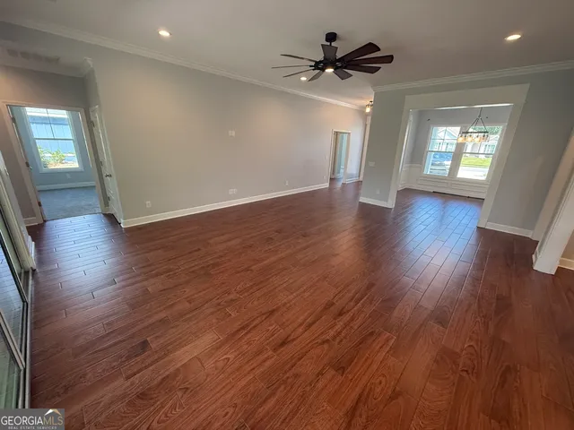 a kitchen with kitchen island a counter top space wooden floor a refrigerator and a sink