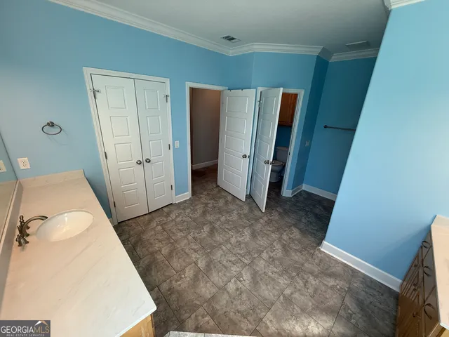 a spacious bathroom with a granite countertop sink and a mirror
