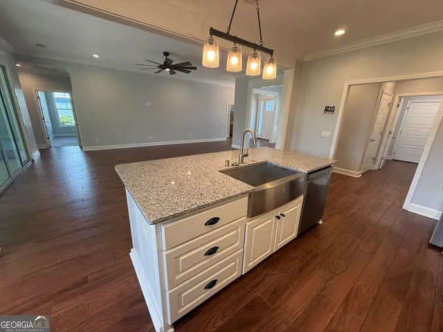 an empty room with windows and ceiling fan