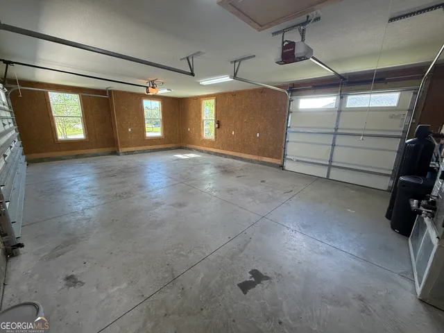 a view of a big room with wooden floor and a kitchen