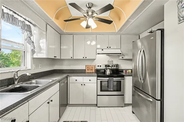 a kitchen with stainless steel appliances cabinets a sink and a window